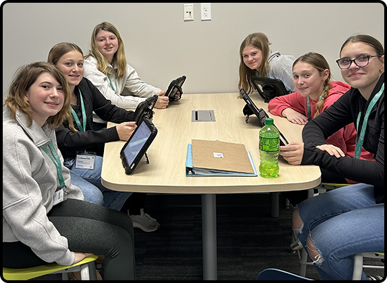 Group of kids gathered using tablets.